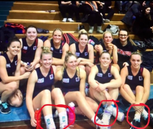 Netball players with ankle braces.